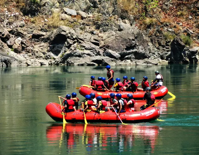 personnes à bord d'un kayak rouge sur une rivière pendant la journée